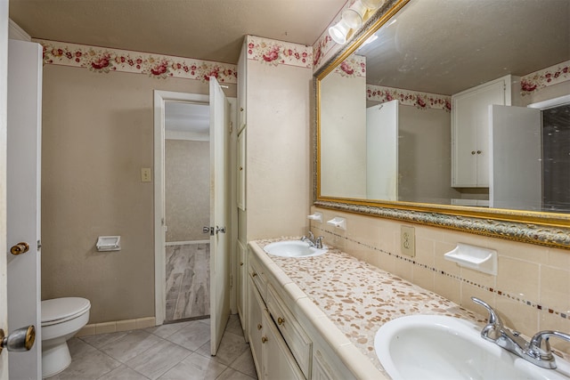 bathroom with vanity, decorative backsplash, toilet, and tile patterned floors