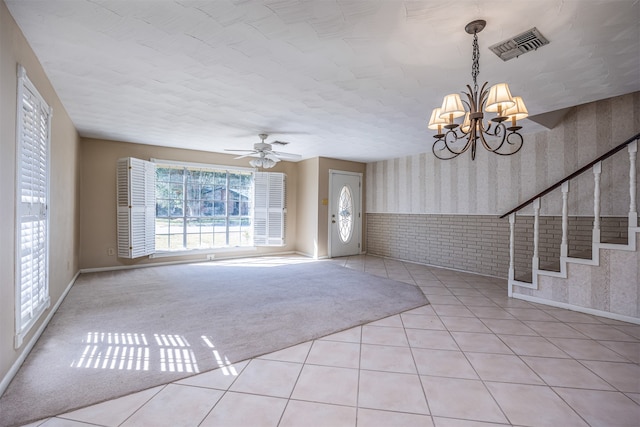 interior space featuring brick wall and ceiling fan with notable chandelier