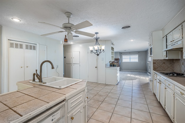 kitchen with sink, tile countertops, stainless steel appliances, pendant lighting, and white cabinets