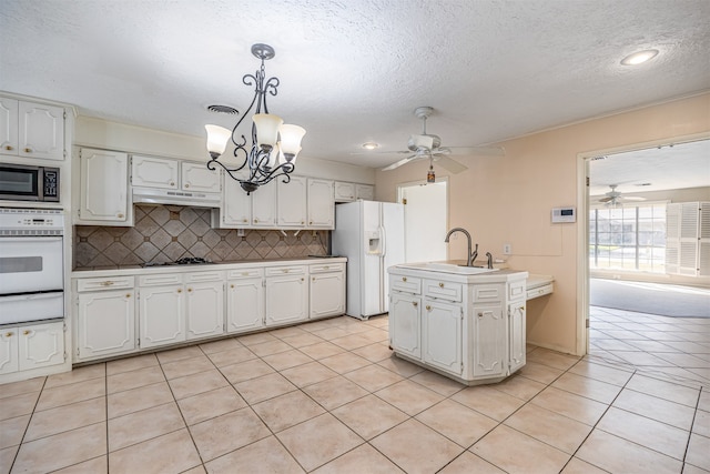 kitchen featuring backsplash, white cabinetry, stainless steel appliances, pendant lighting, and light tile patterned floors