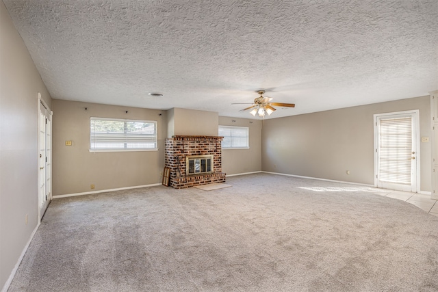 unfurnished living room with a wealth of natural light, a brick fireplace, and light colored carpet