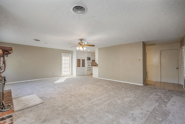 unfurnished living room featuring light carpet, a textured ceiling, and ceiling fan