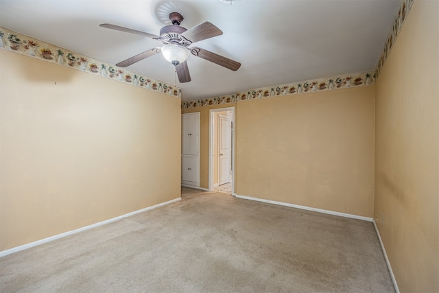 carpeted spare room with ceiling fan