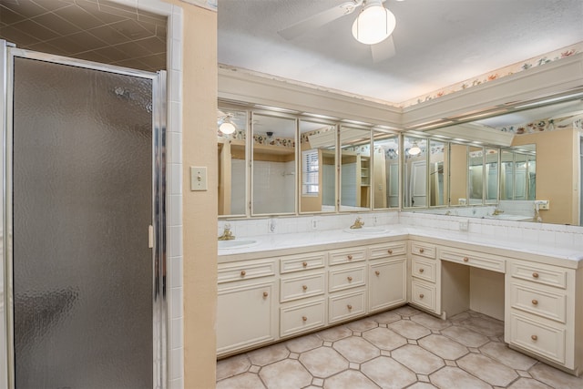 bathroom with vanity, a shower with shower door, and ceiling fan