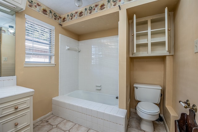 full bathroom with toilet, tile patterned flooring, tiled shower / bath combo, vanity, and a textured ceiling