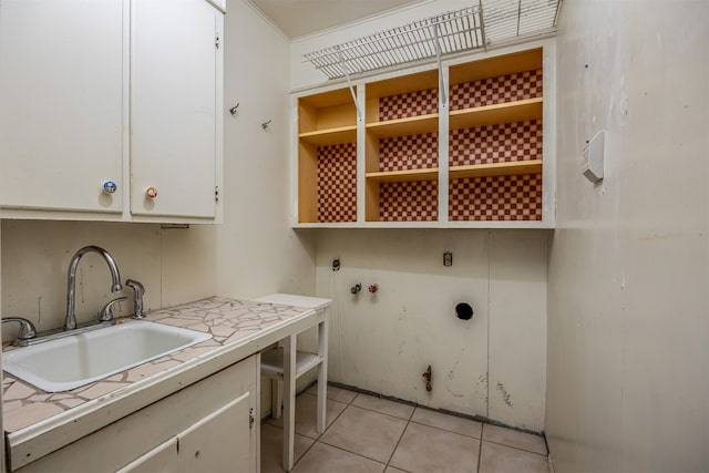 clothes washing area with sink, light tile patterned flooring, cabinets, and hookup for an electric dryer