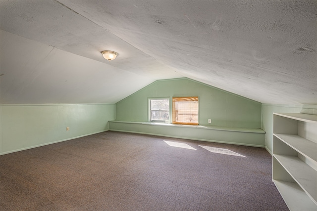 bonus room with vaulted ceiling, a textured ceiling, and carpet flooring