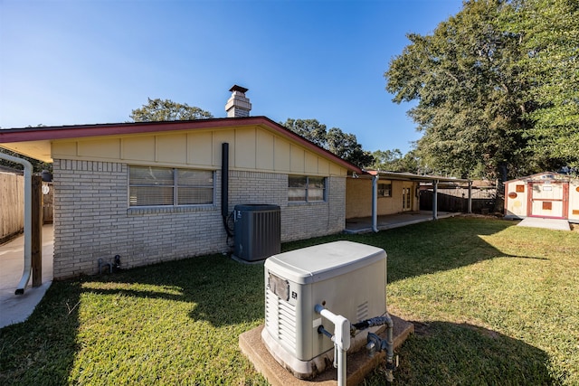 view of home's exterior featuring central air condition unit, a shed, a patio, and a lawn