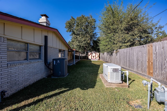 view of yard with central AC and a storage shed