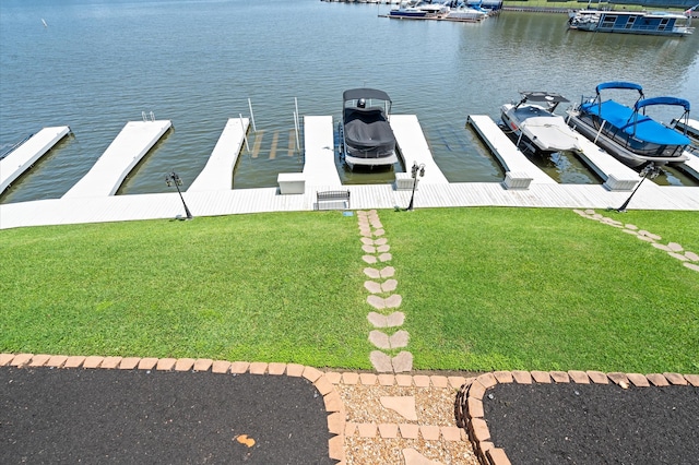 view of dock with a water view and a yard