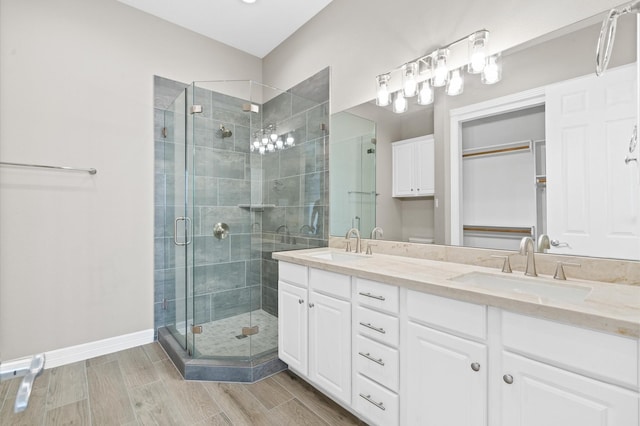 168 Lake Point Blvd Unit C202, Conroe, TX 77356 - bathroom with a stall shower, double vanity, wood finished floors, and a closet