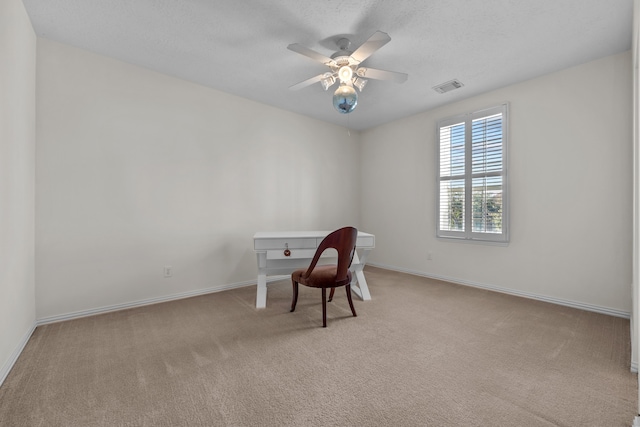 unfurnished office featuring ceiling fan and light carpet