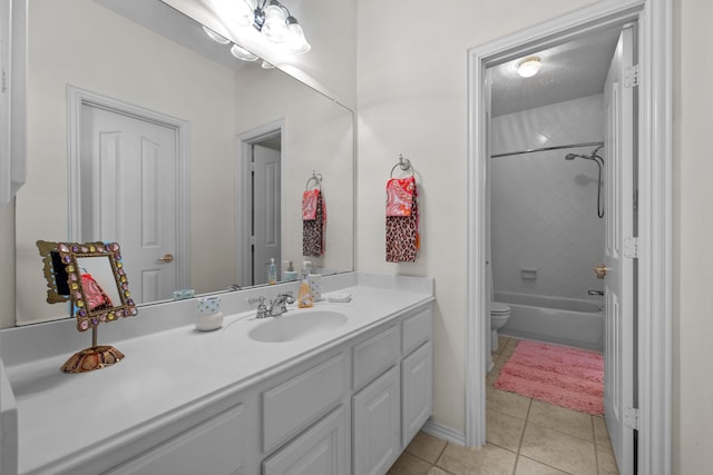 full bathroom featuring tiled shower / bath, vanity, toilet, and tile patterned floors