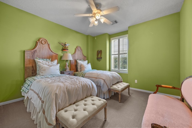 carpeted bedroom featuring ceiling fan and a textured ceiling