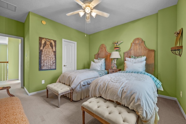 bedroom with light carpet, a textured ceiling, and ceiling fan