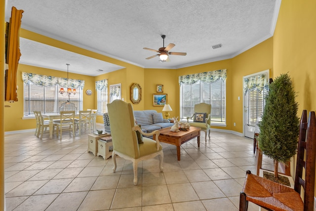 tiled living room with ceiling fan, a textured ceiling, ornamental molding, and a wealth of natural light