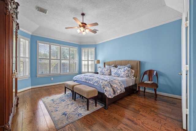 bedroom featuring ceiling fan, crown molding, a textured ceiling, and dark hardwood / wood-style floors