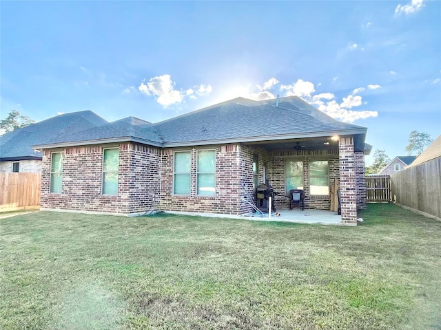 rear view of property with a patio, ceiling fan, and a yard