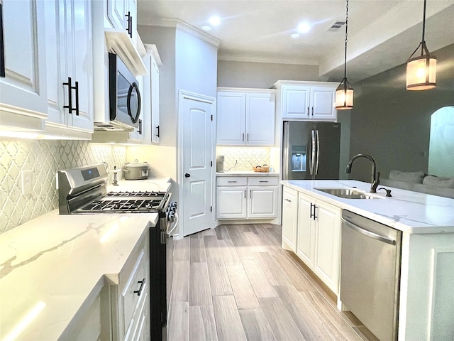 kitchen with white cabinetry, sink, decorative light fixtures, and appliances with stainless steel finishes