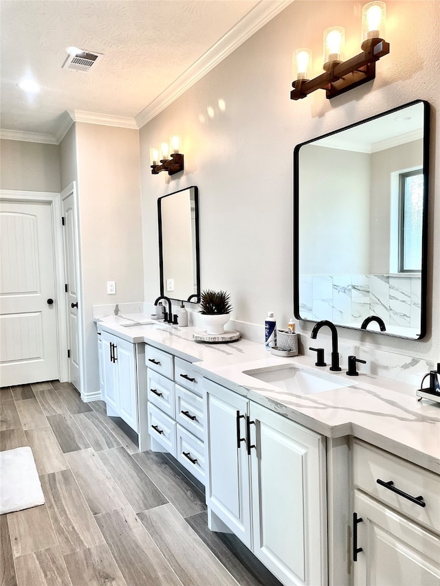 bathroom with hardwood / wood-style flooring, vanity, a textured ceiling, and crown molding