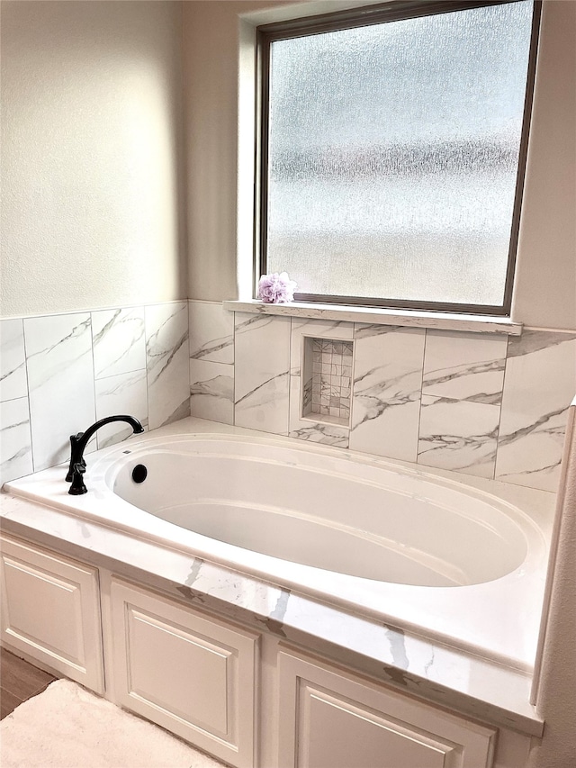 bathroom with a wealth of natural light and a tub