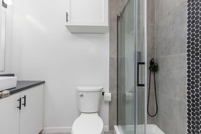 bathroom featuring an enclosed shower, vanity, and toilet