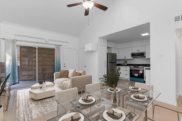 dining room with light hardwood / wood-style flooring, high vaulted ceiling, ceiling fan, and crown molding