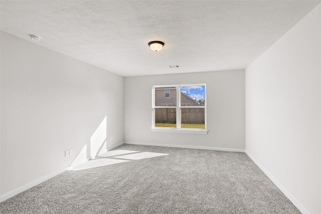 empty room featuring a textured ceiling and carpet floors