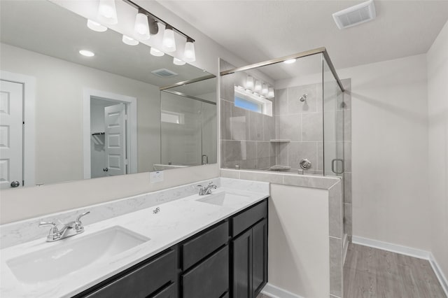 bathroom with wood-type flooring, vanity, and walk in shower