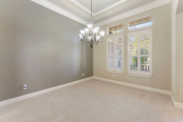 spare room with carpet, ornamental molding, and a chandelier