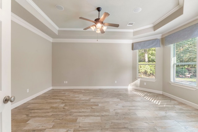 empty room featuring ceiling fan, crown molding, and a raised ceiling