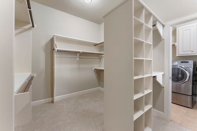 walk in closet featuring light carpet and washer / dryer