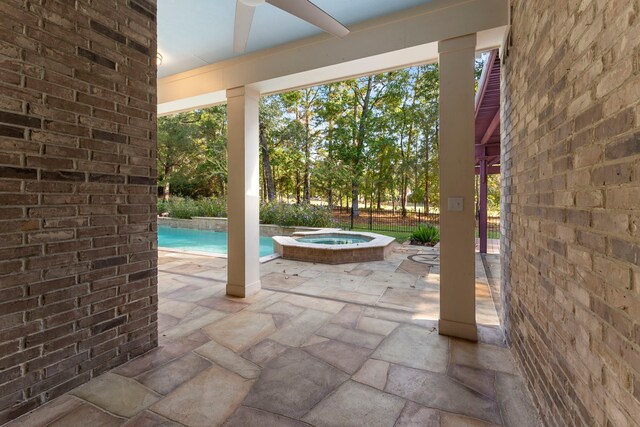 view of patio / terrace with ceiling fan and a pool with hot tub