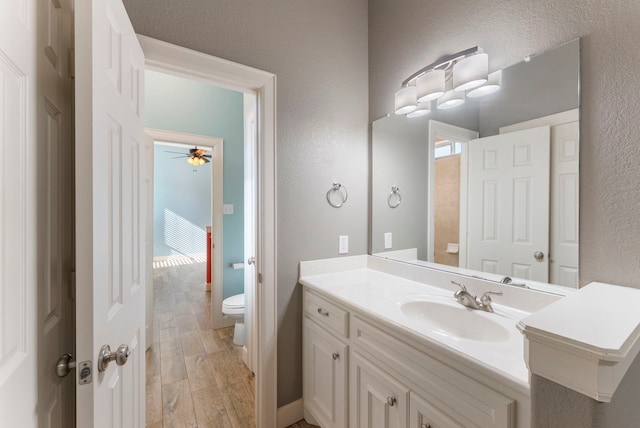 bathroom with hardwood / wood-style flooring, toilet, and vanity