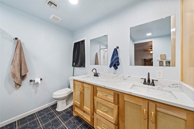 bathroom with toilet, vanity, and ceiling fan