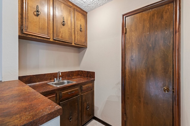 kitchen featuring a textured ceiling and sink