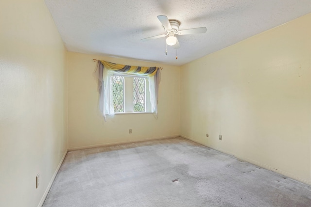 carpeted empty room featuring ceiling fan and a textured ceiling