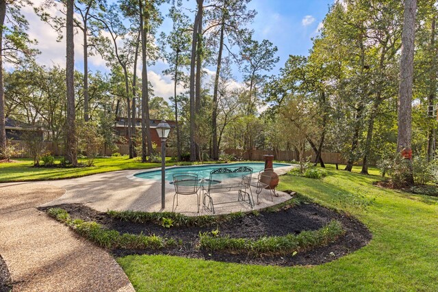 view of swimming pool featuring a patio area and a yard