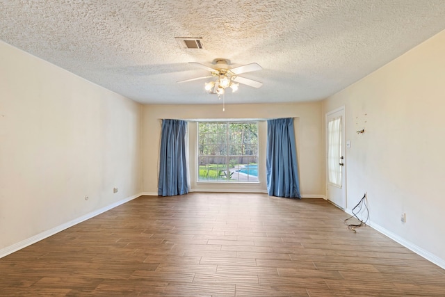 empty room with ceiling fan, wood-type flooring, and a textured ceiling