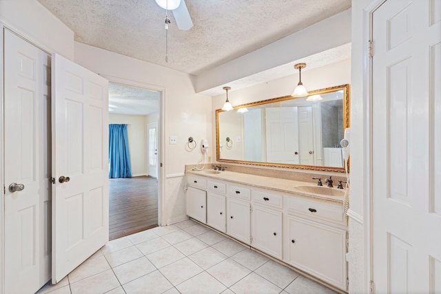 bathroom featuring tile patterned floors, vanity, ceiling fan, and a textured ceiling