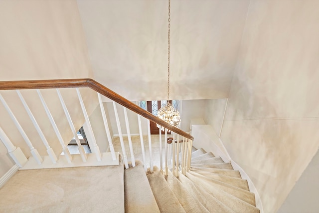 stairs featuring a chandelier