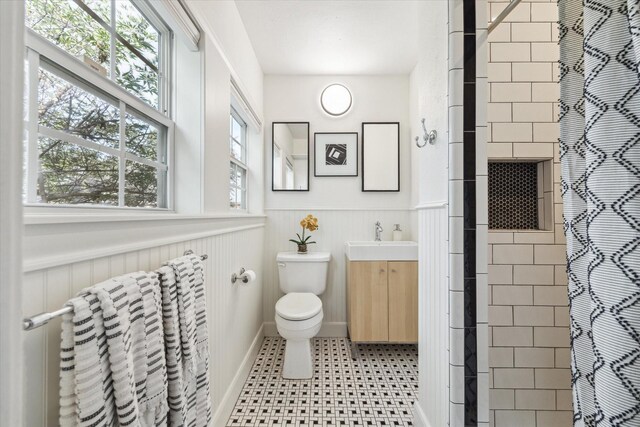 bathroom with a shower with curtain, vanity, toilet, and plenty of natural light