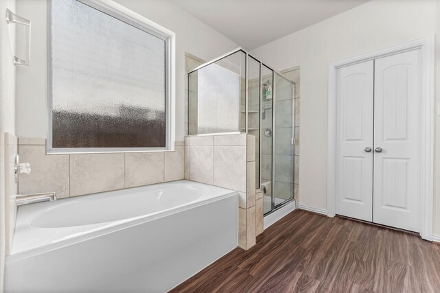 bathroom with plus walk in shower and hardwood / wood-style flooring