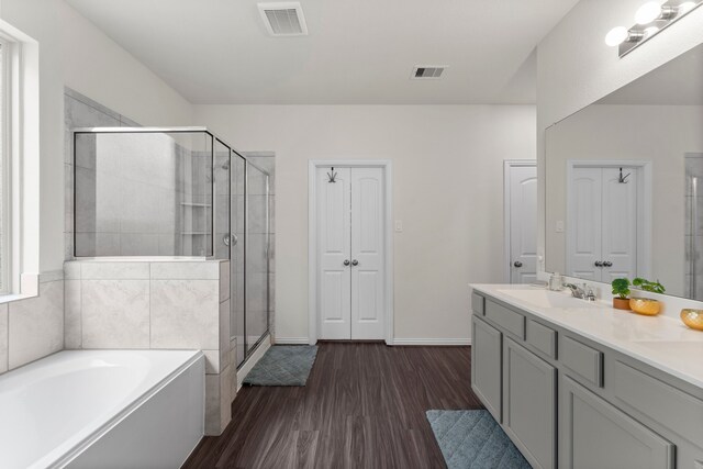 bathroom featuring vanity, wood-type flooring, and separate shower and tub