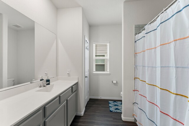 bathroom featuring toilet, hardwood / wood-style flooring, and vanity