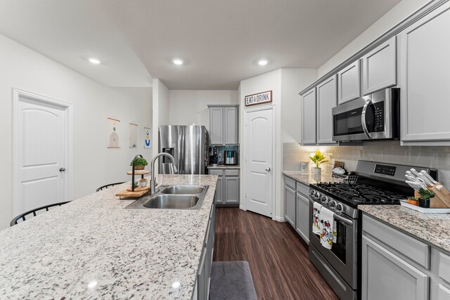 kitchen with dark wood-type flooring, stainless steel appliances, sink, and gray cabinets