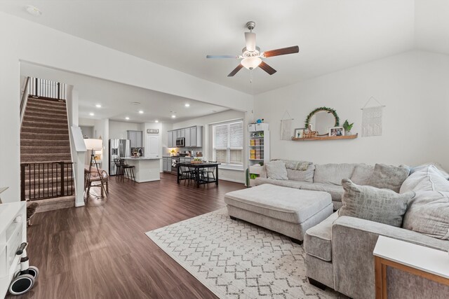 living room with dark wood-type flooring, vaulted ceiling, and ceiling fan