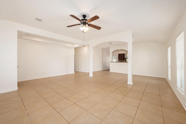 unfurnished living room with a ceiling fan, arched walkways, visible vents, and light tile patterned floors