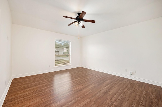 unfurnished room featuring a ceiling fan, baseboards, and dark wood-type flooring