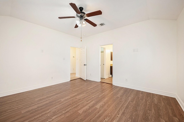 empty room featuring a ceiling fan, visible vents, wood finished floors, baseboards, and lofted ceiling